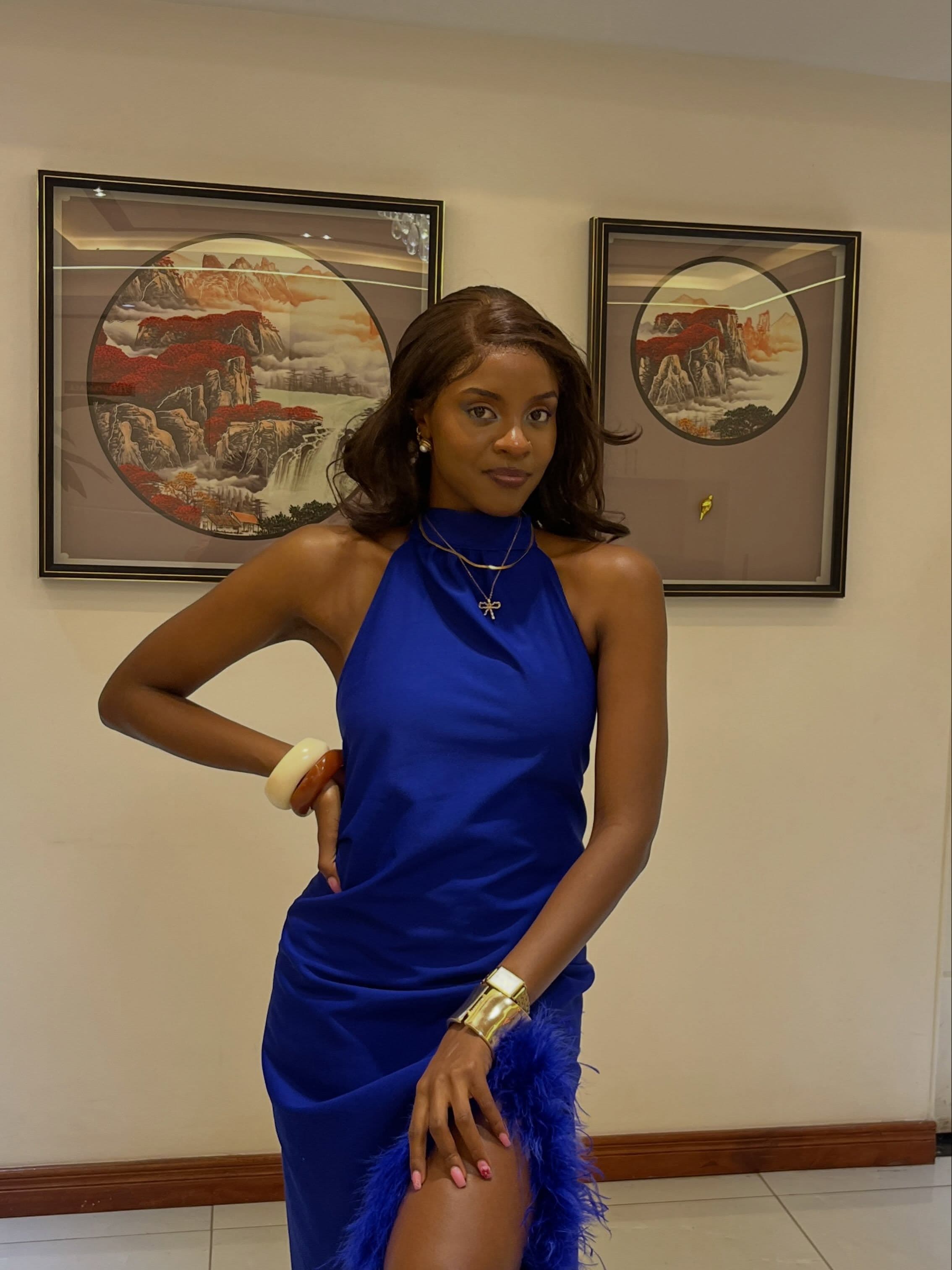 Woman wearing a cobalt blue halter dress with feather detailing